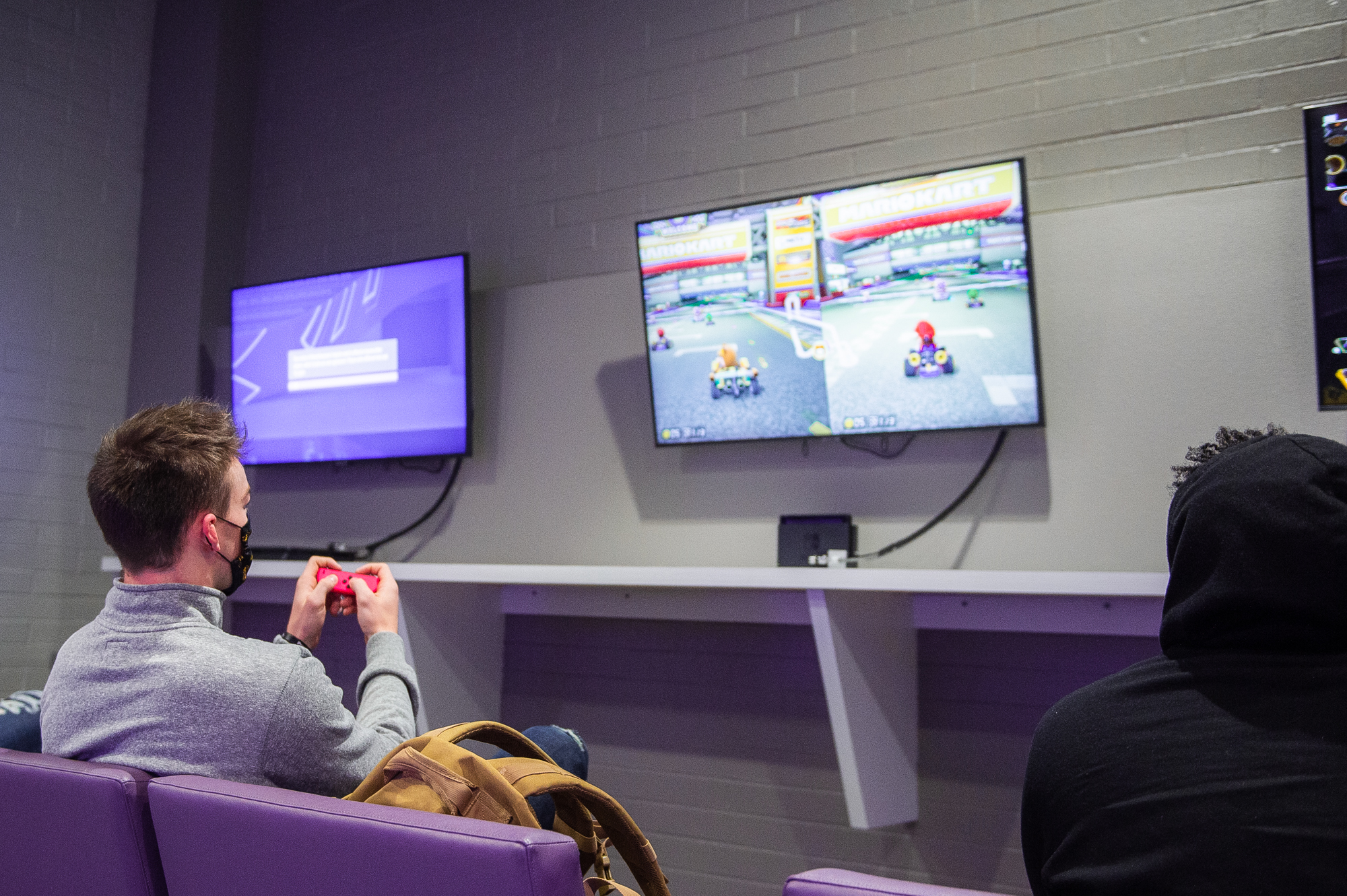 Two male students play Mario Kart.