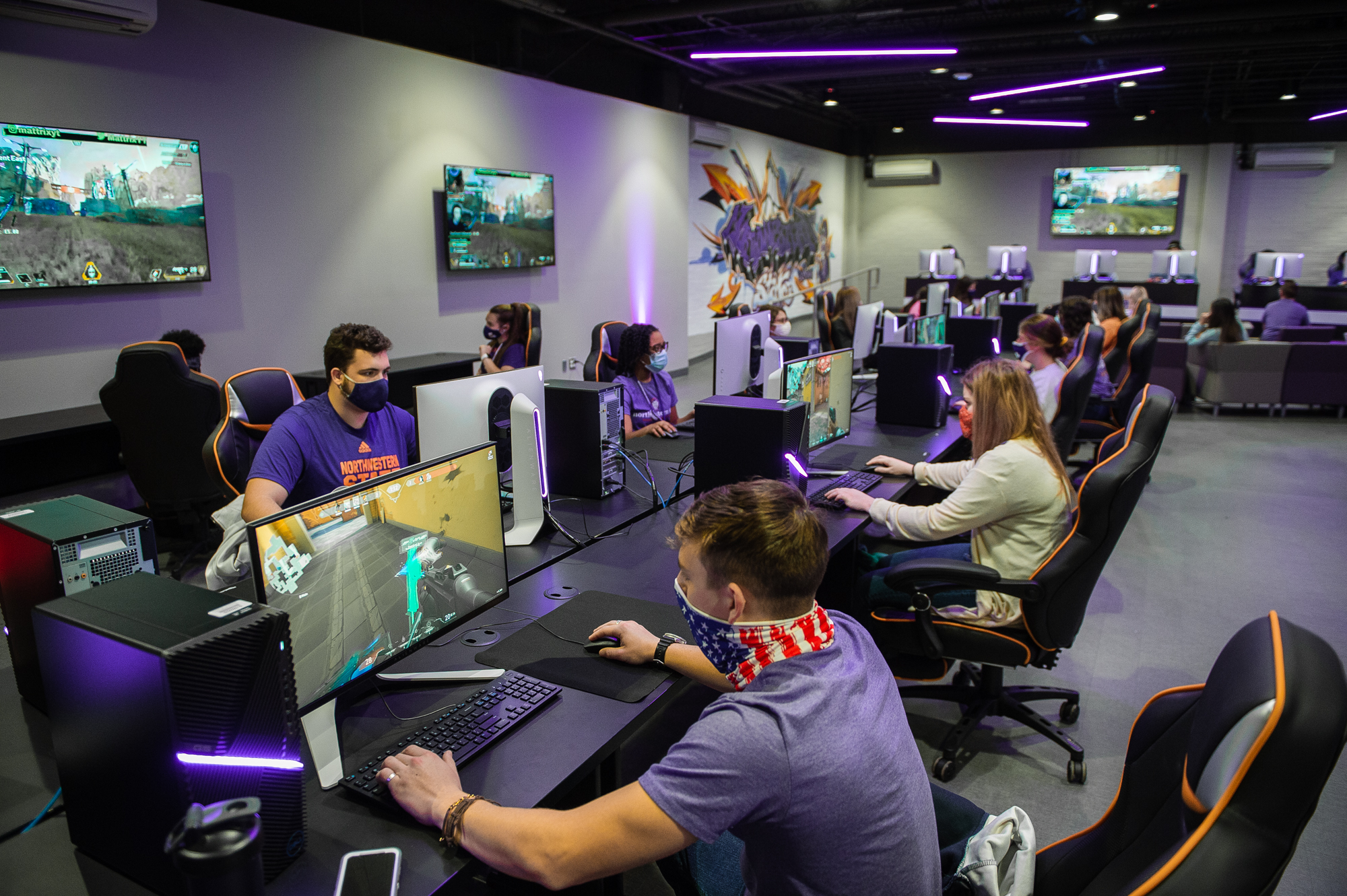 Students play a first-person shooter game at desktop PCs in the NSU Esports Venue.