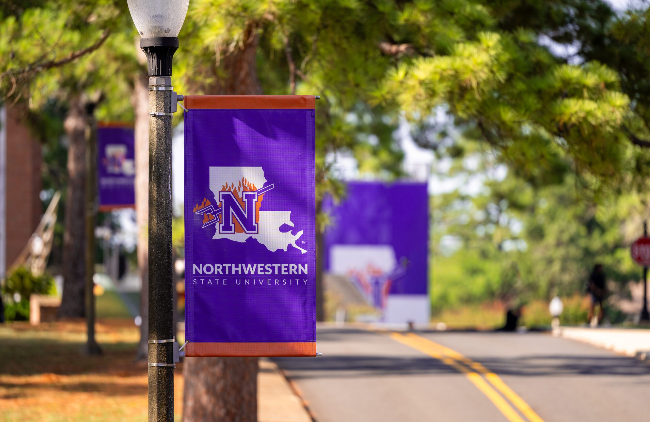 A Northwestern State University banner displays the university’s logo and colors on the Natchitoches campus.