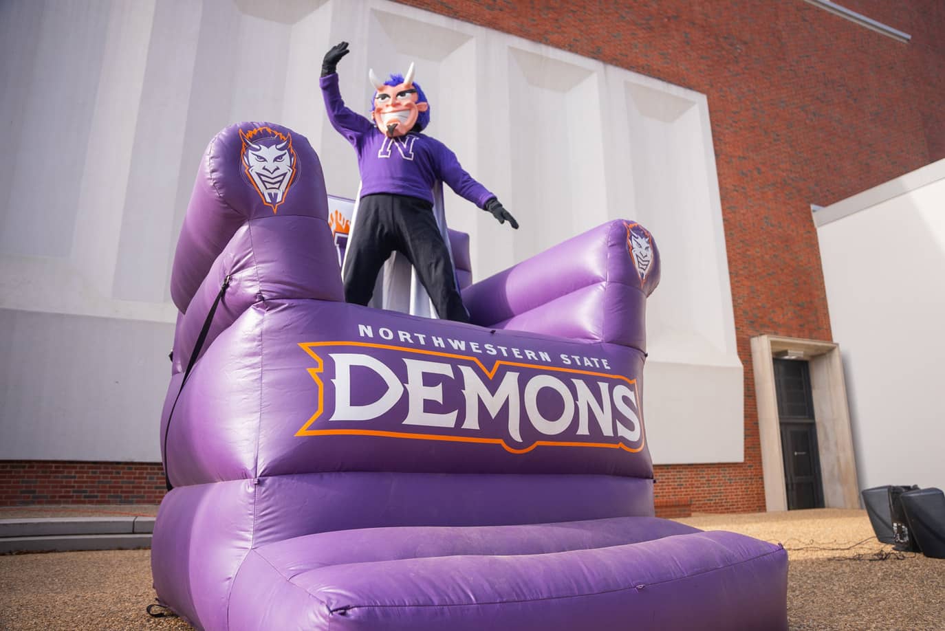 NSULA mascot standing on demons purple chair