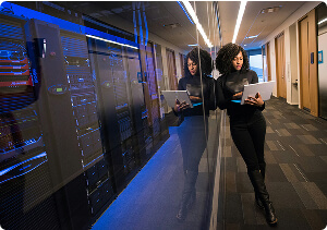 A person holding a laptop in a hallway.