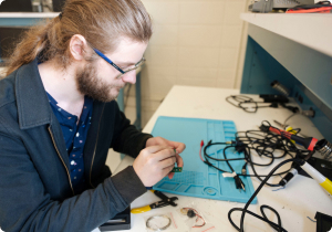 Engineering student disconnecting wires for school project