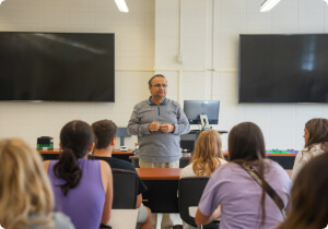 An instructor speaking in front of students.