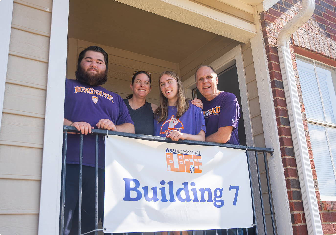 People standing at a balcony in an NSU dorm.