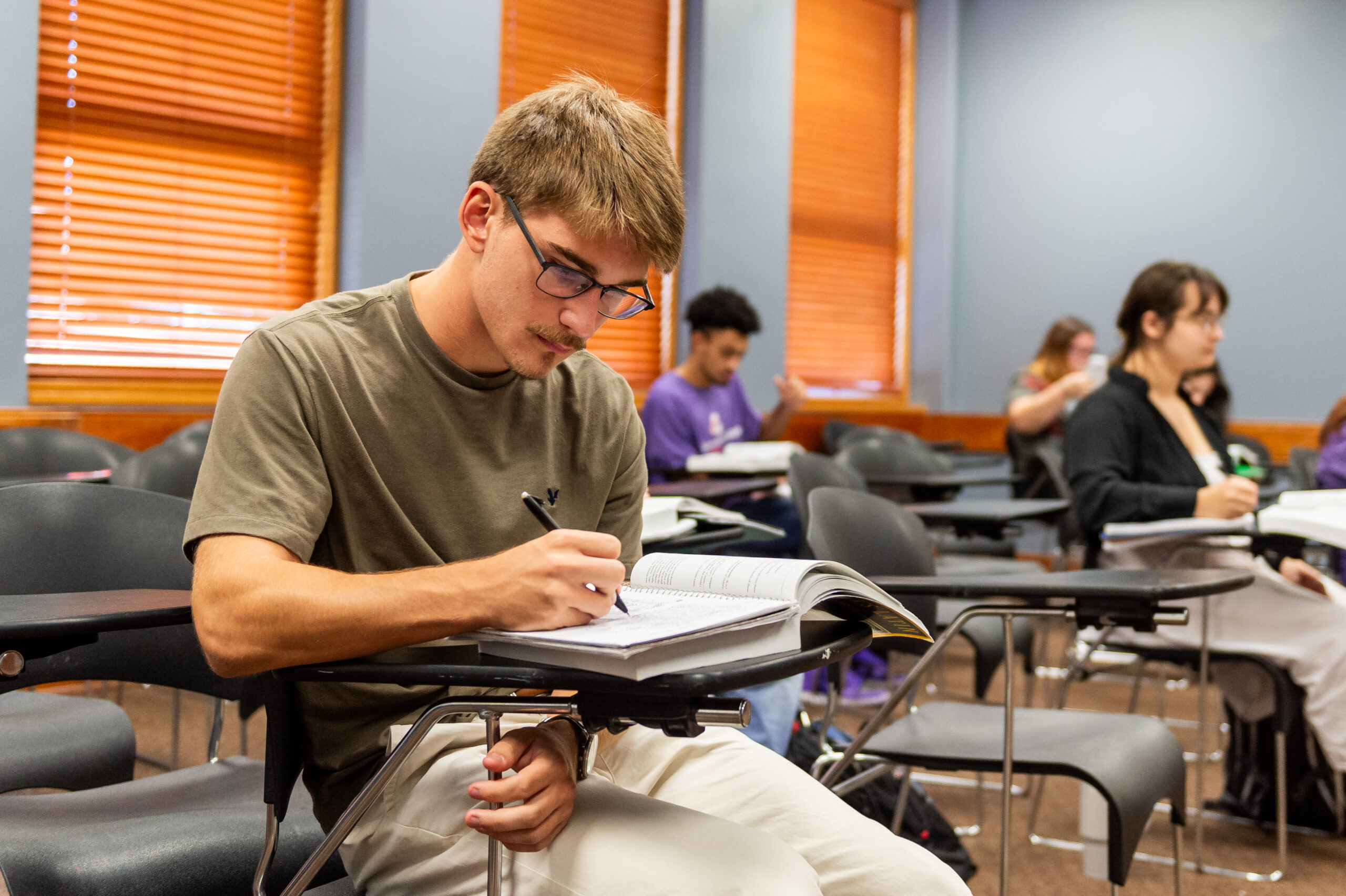 NSU student completing work in notebook
