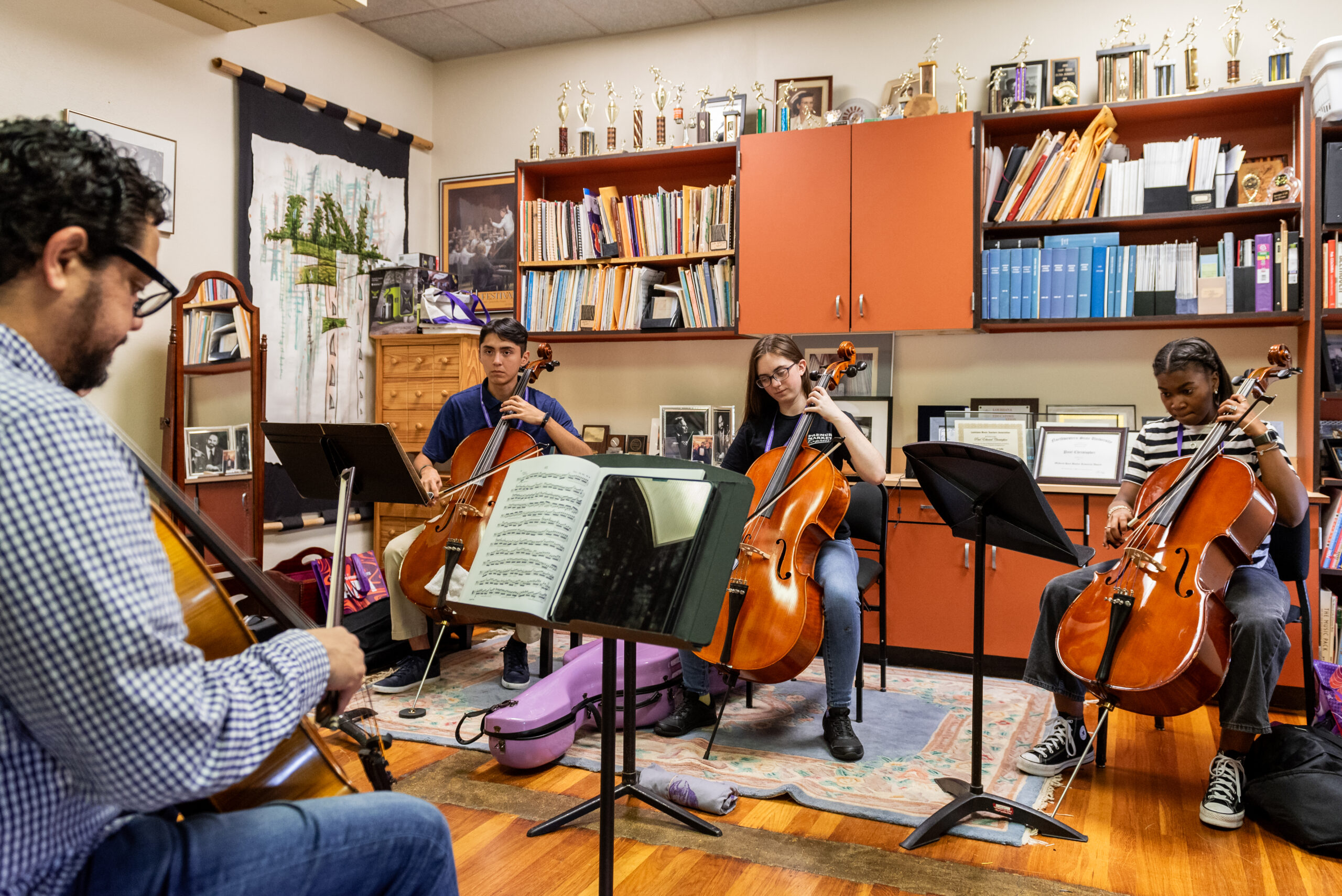 NSU Music instructor assists students with string instrument