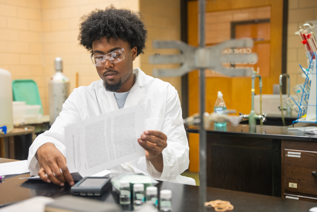 NSU student reads lab report in biology lab