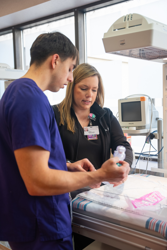 NSU instructor assists student with hands-on learning