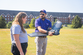 NSU faculty member and student flying a drone.