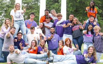 NSU students pose for a photo in front of the 3 Columns