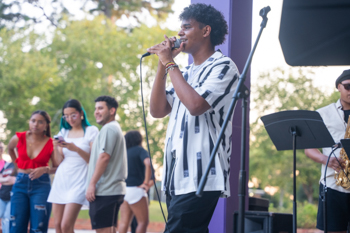 NSU student speaks to a crowd a Seven Oaks Stage on campus.