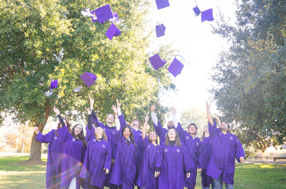 International Students graduating throwing caps into the air.