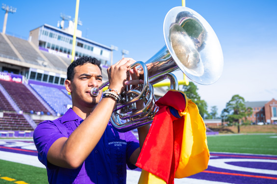 International Student playing musical instrument inside Turpin Stadium.
