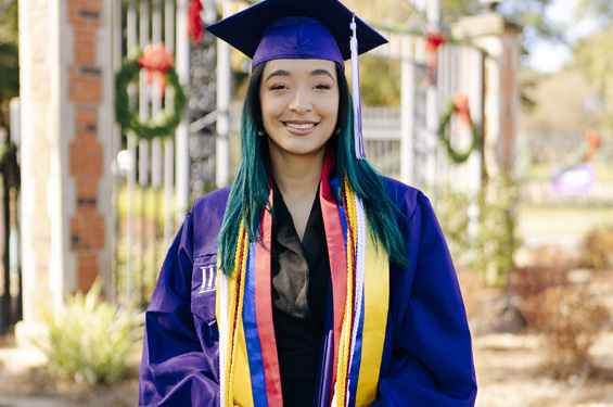 International Student in front of entrance gates to NSU