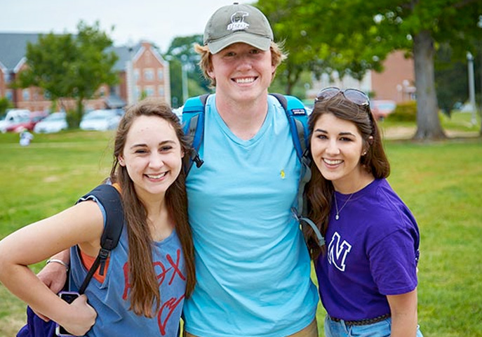 Three NSU students on campus near living villages.