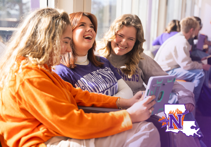 NSU students sitting together looking at table device in Student Union