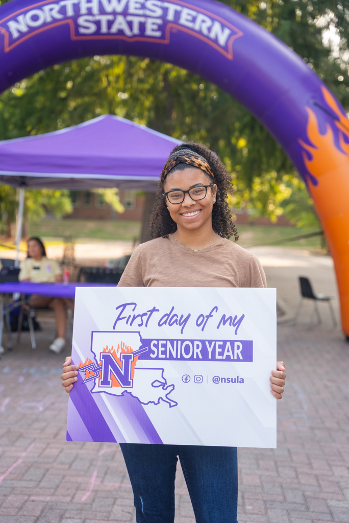 An NSU student poses for a first day of class photo