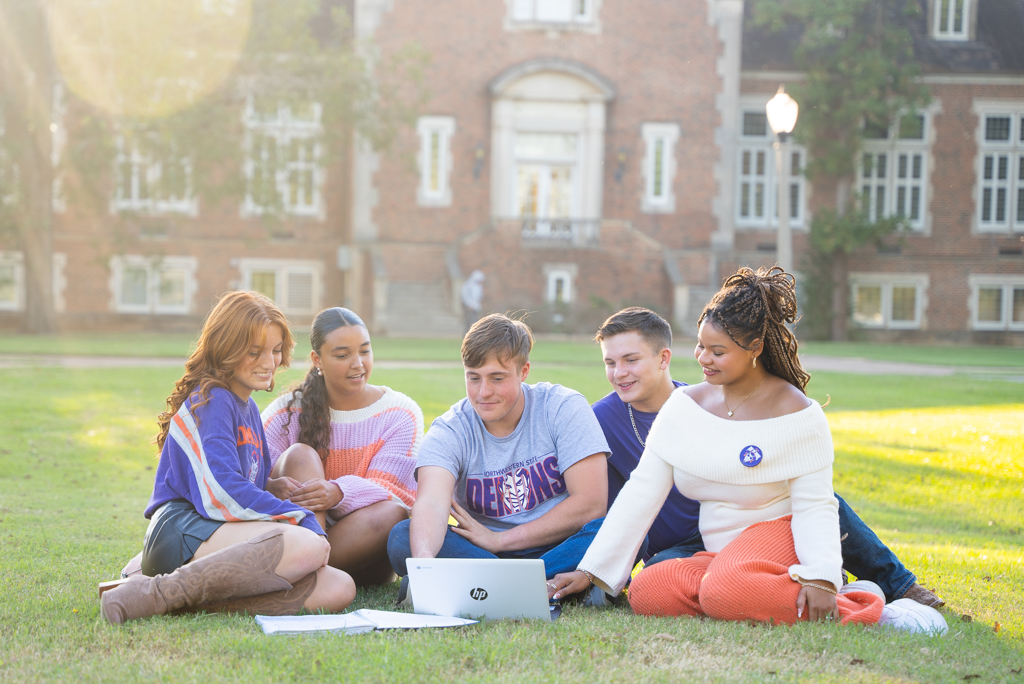 A group of students work together on the lawn of Normal Hill