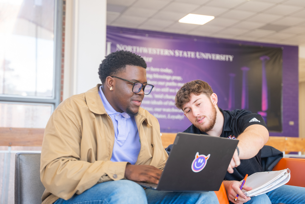 Two NSU students work on a laptop in the Student Union lobby