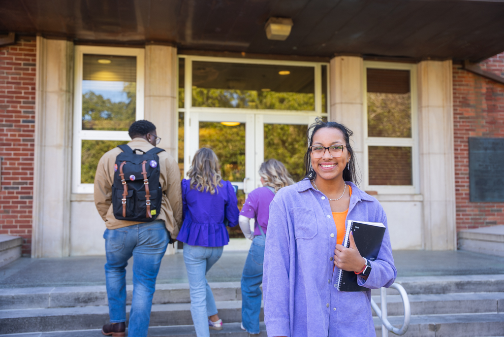 An NSU student poses outside of an academic building