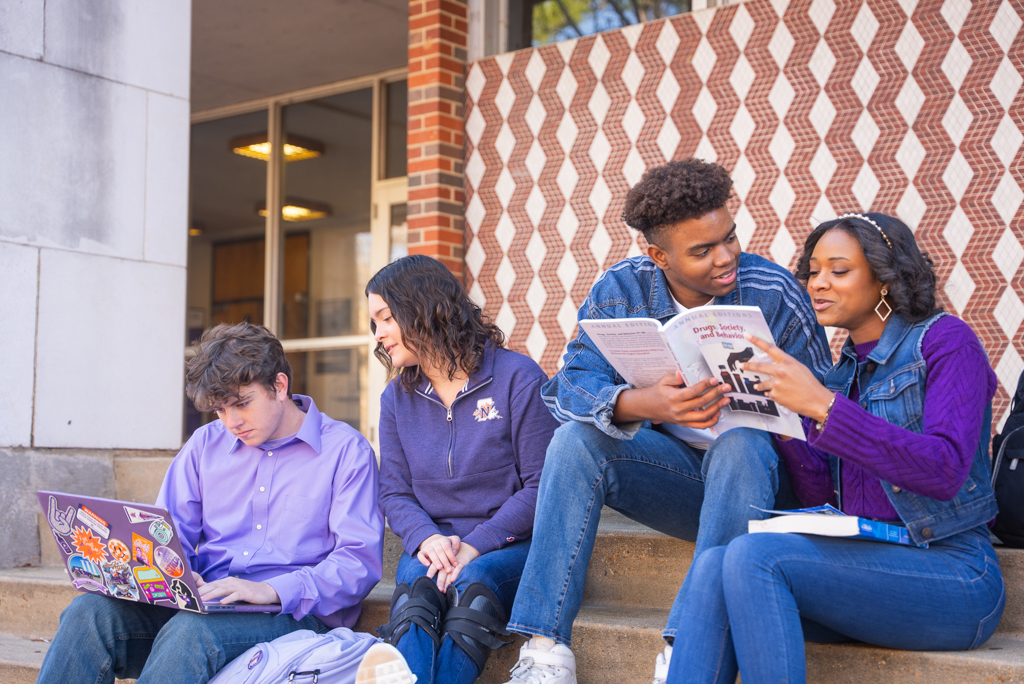 A group of NSU students complete schoolwork outside of Kyser Hall