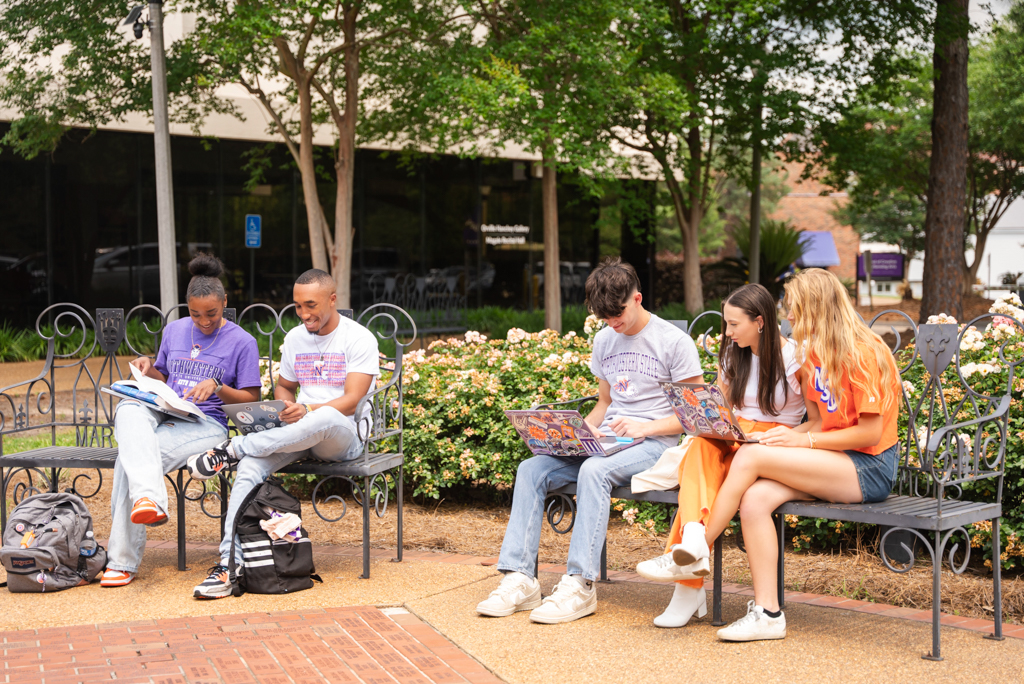 A group of NSU students gather to complete schoolwork in the Alumni Plaza