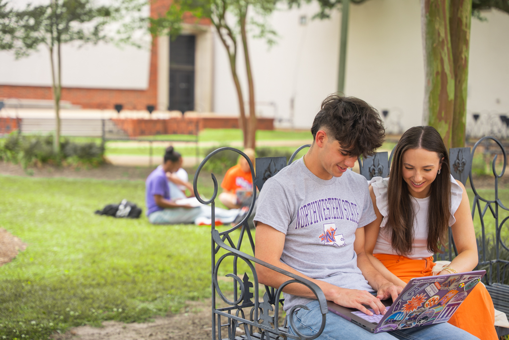 NSU students working outside on a bench
