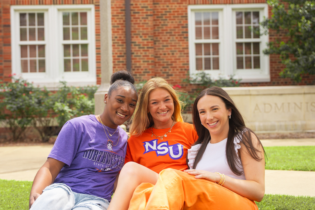 A group of NSU students pose for a photo in front of Caspari Hall