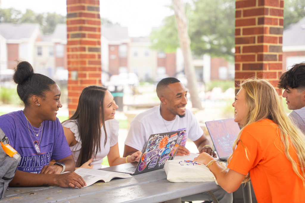 A group of NSU students studying under the pavilion on campus