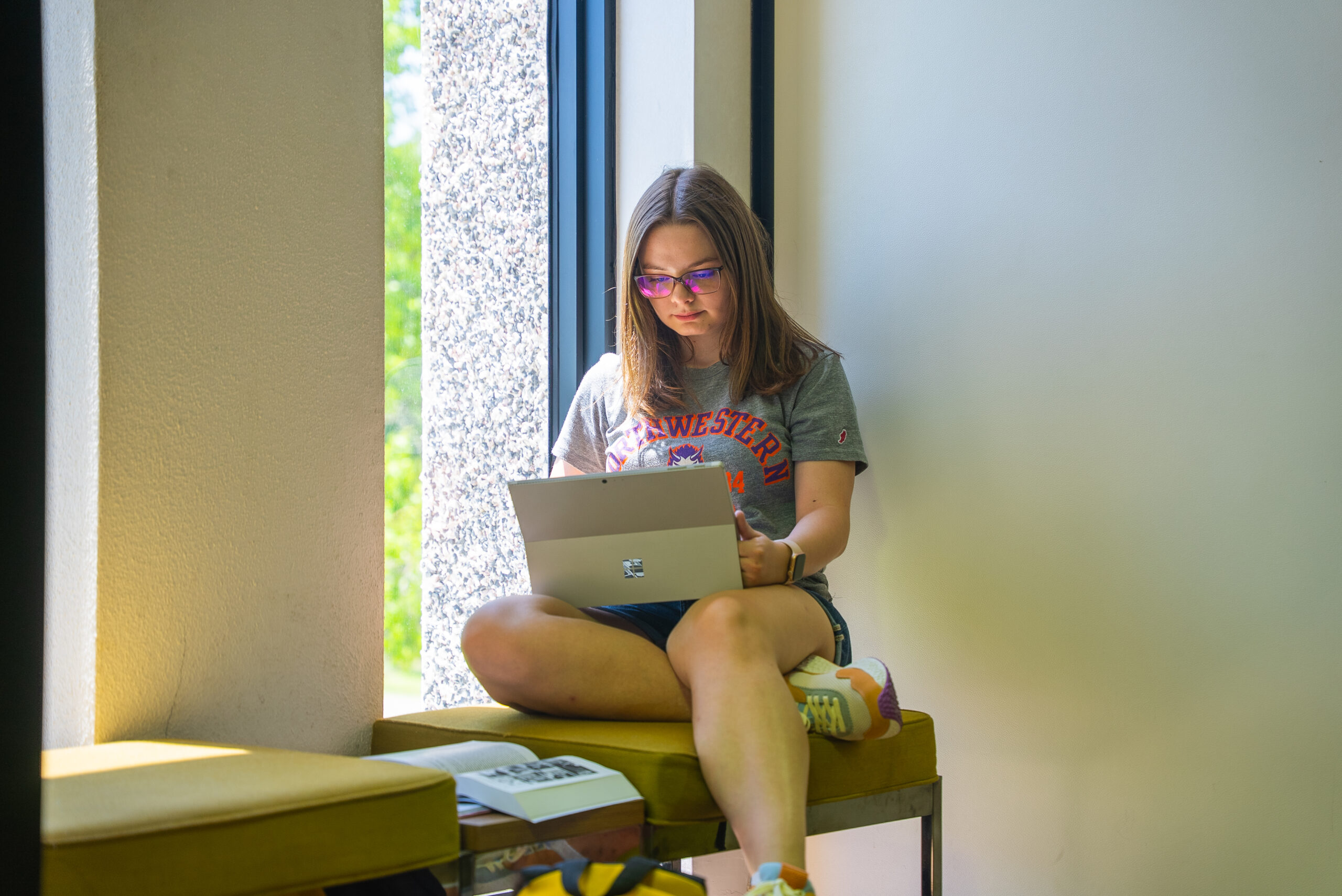 NSU student studies on their laptop in the library