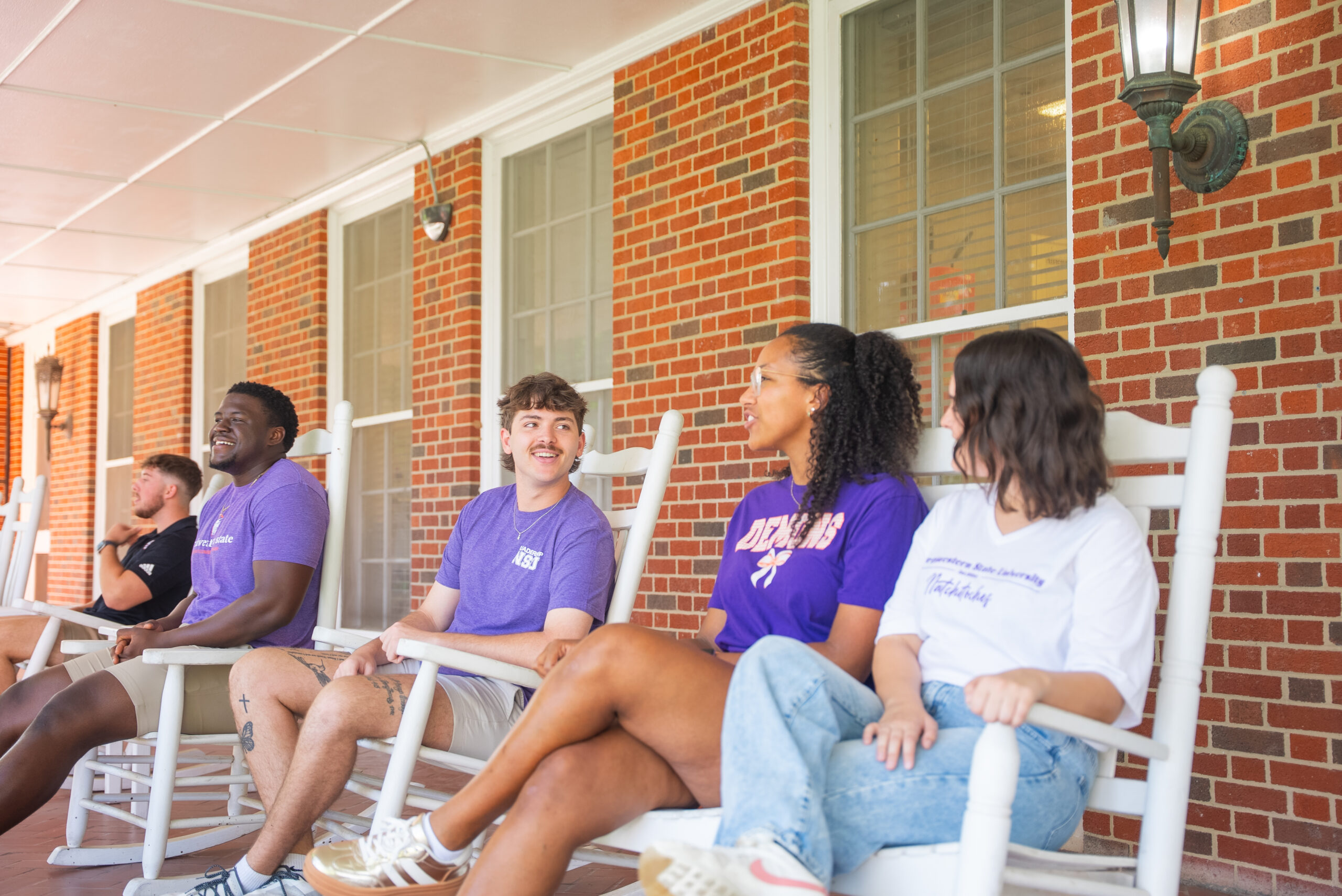 NSU students sit in rocking chairs at Varnado Hall