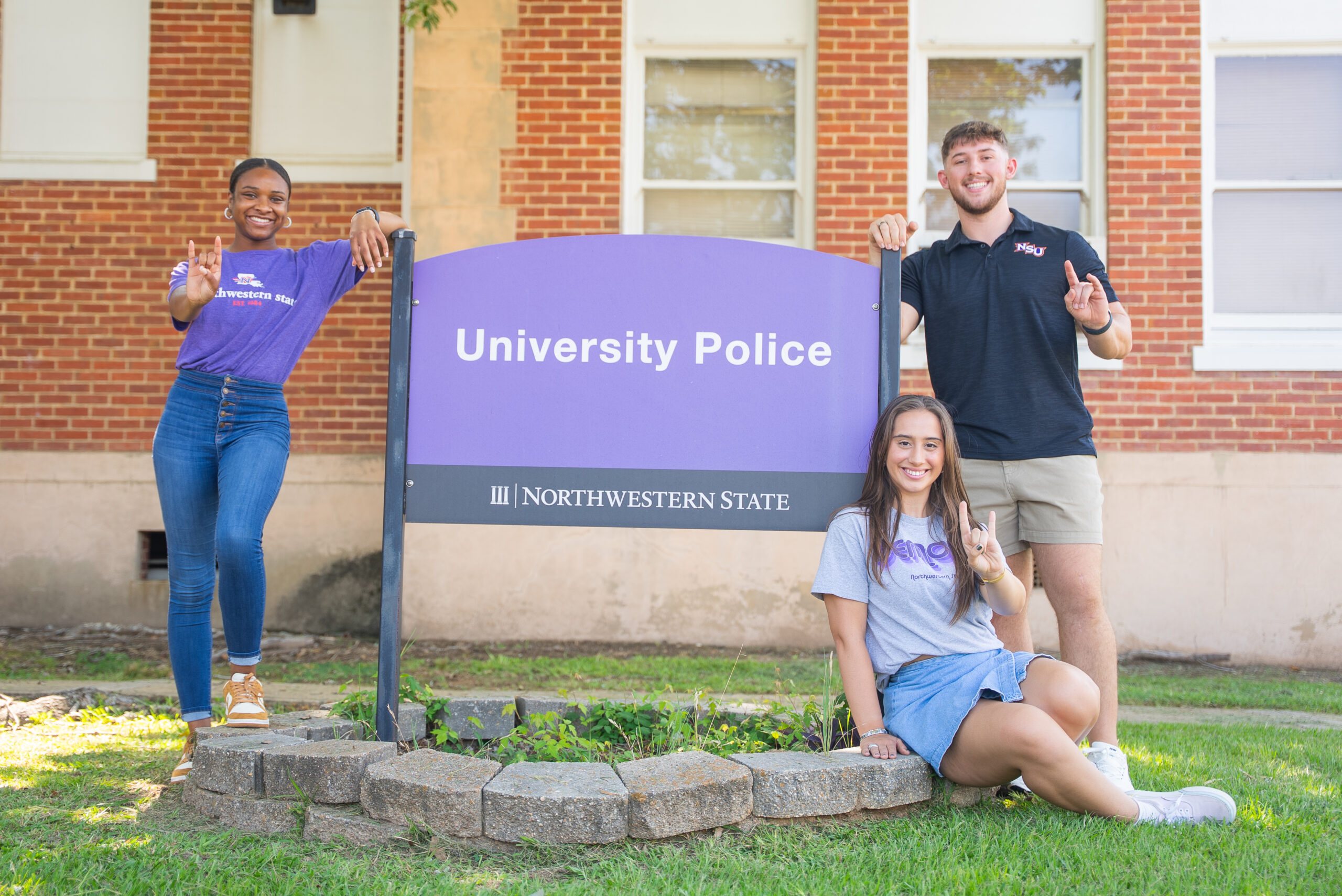 NSU students pose for a photo in front of the campus police station