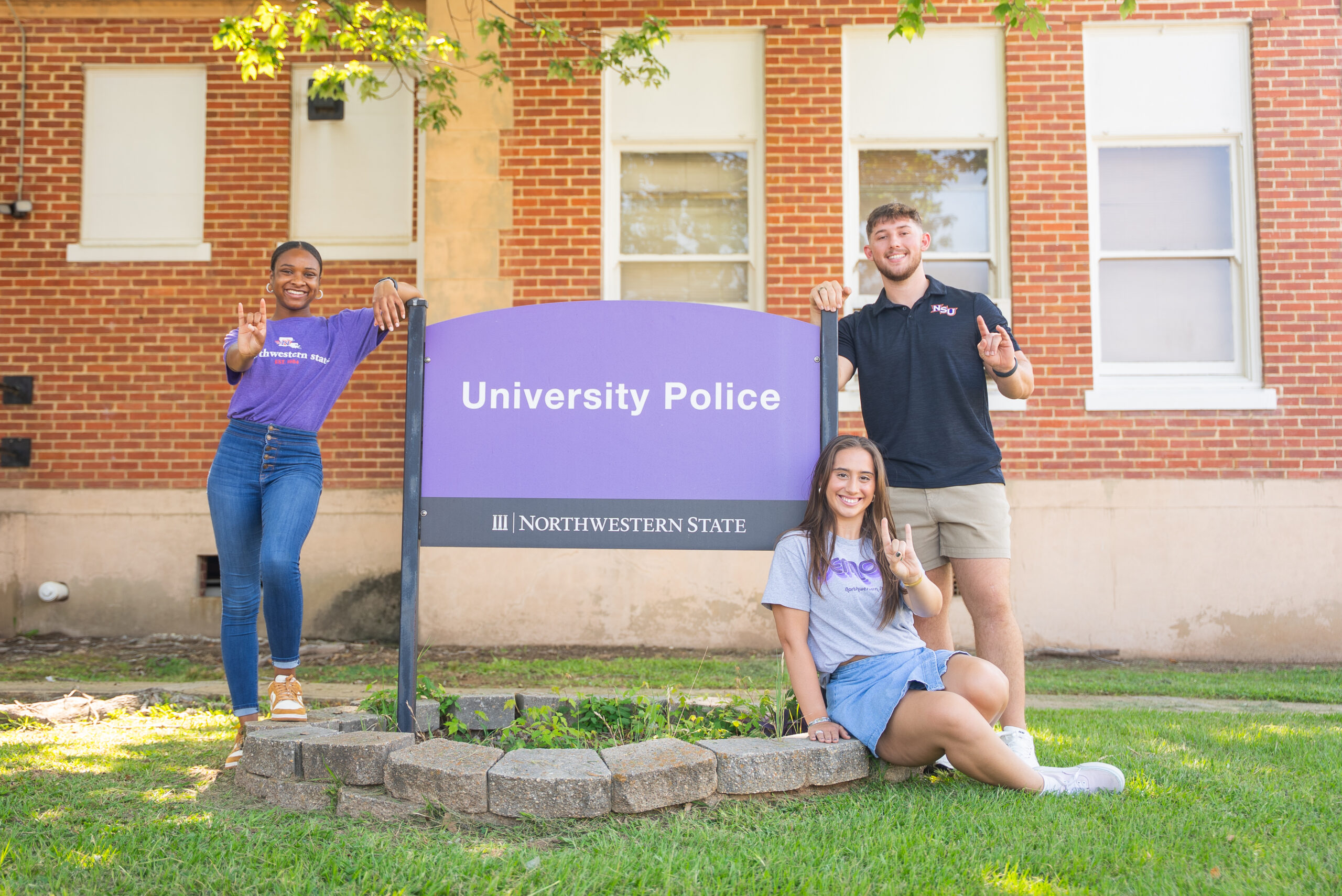 NSU students pose for a photo in front of the campus police station
