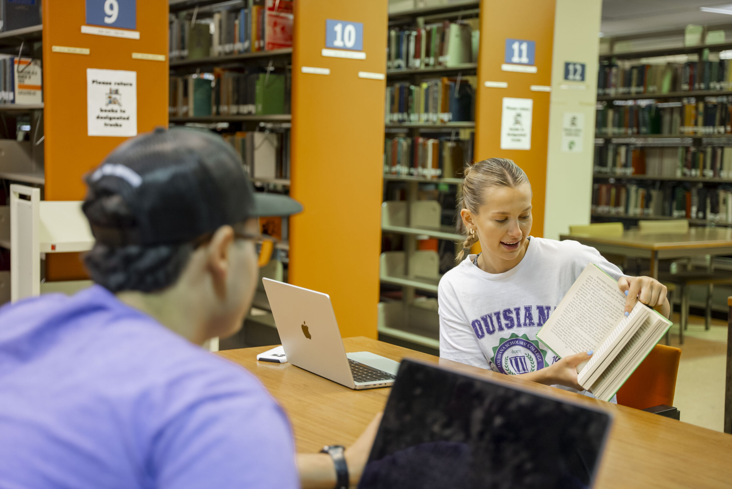 2 NSU students completing homework in the library