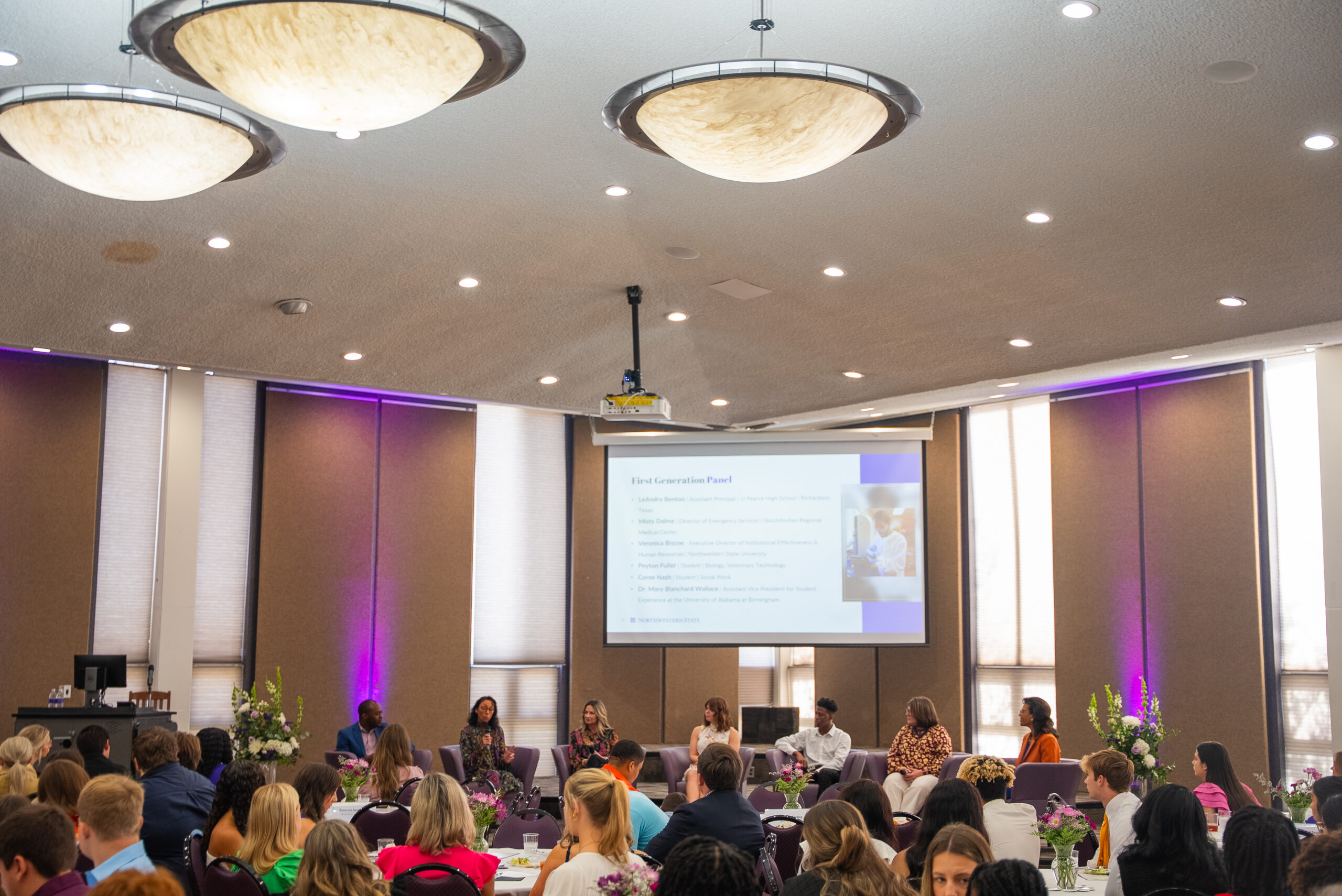 First-generation panelists speak in front of luncheon