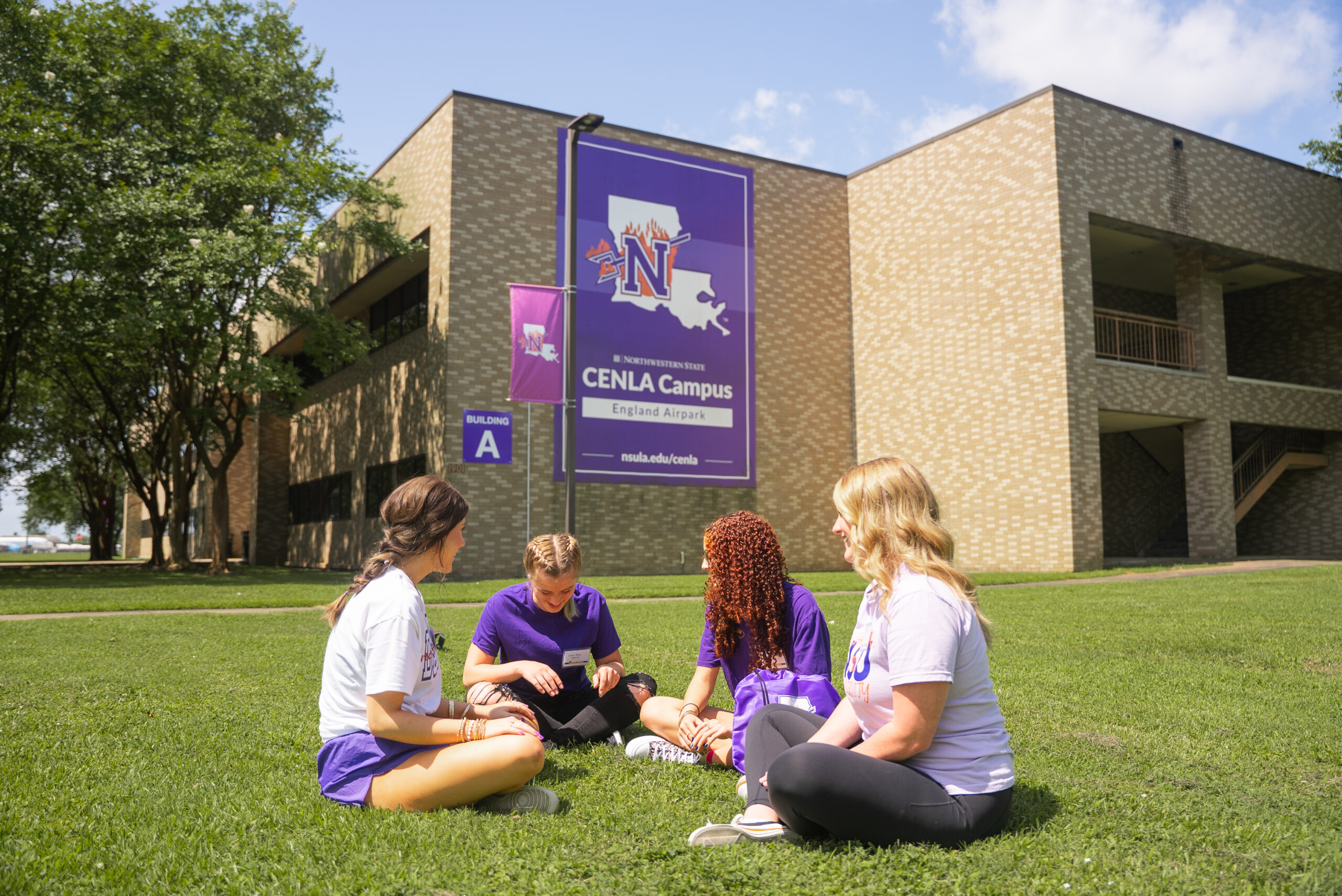 NSU students sit on lawn of CENLA Campus academic building