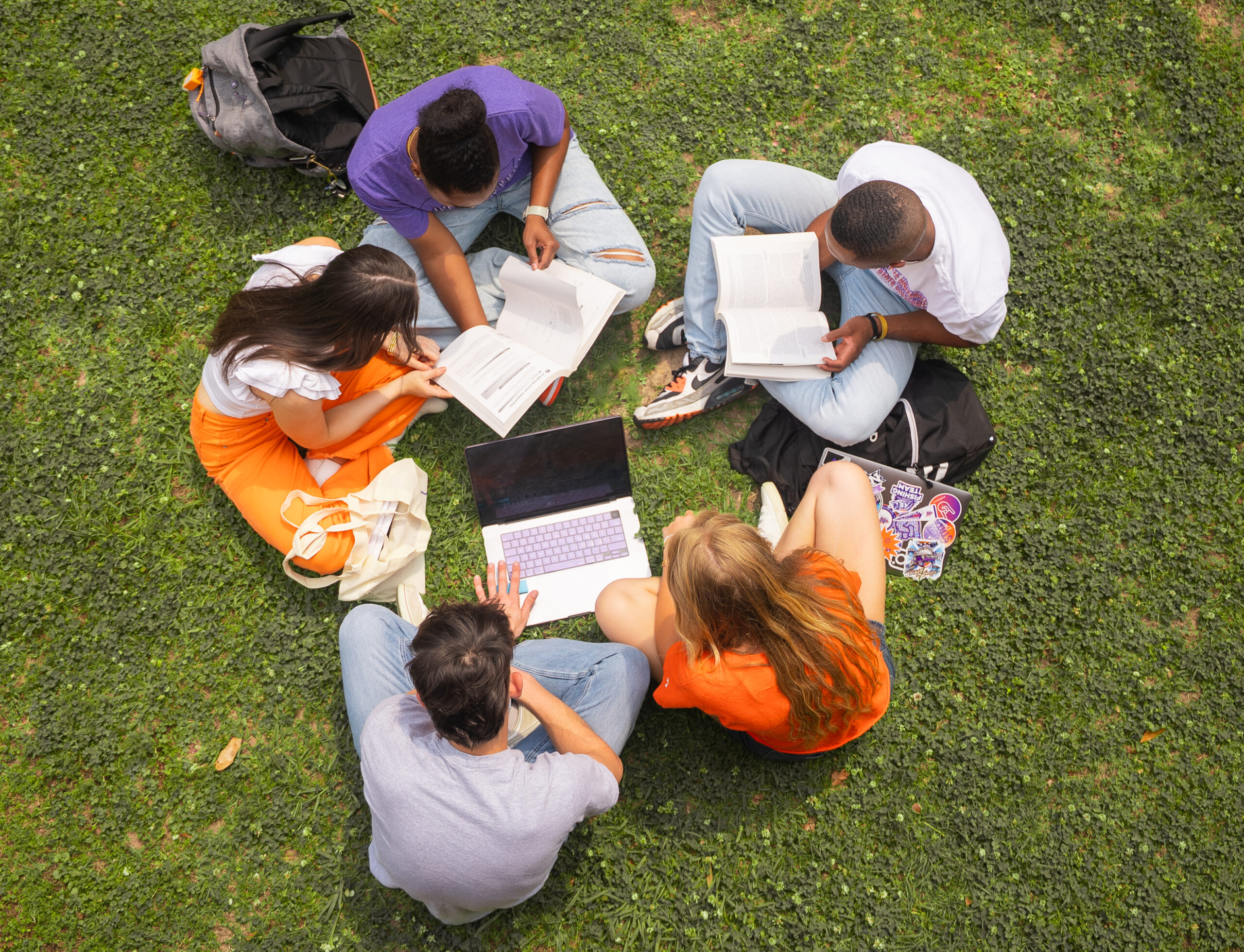 A group of NSU students complete homework on the lawn