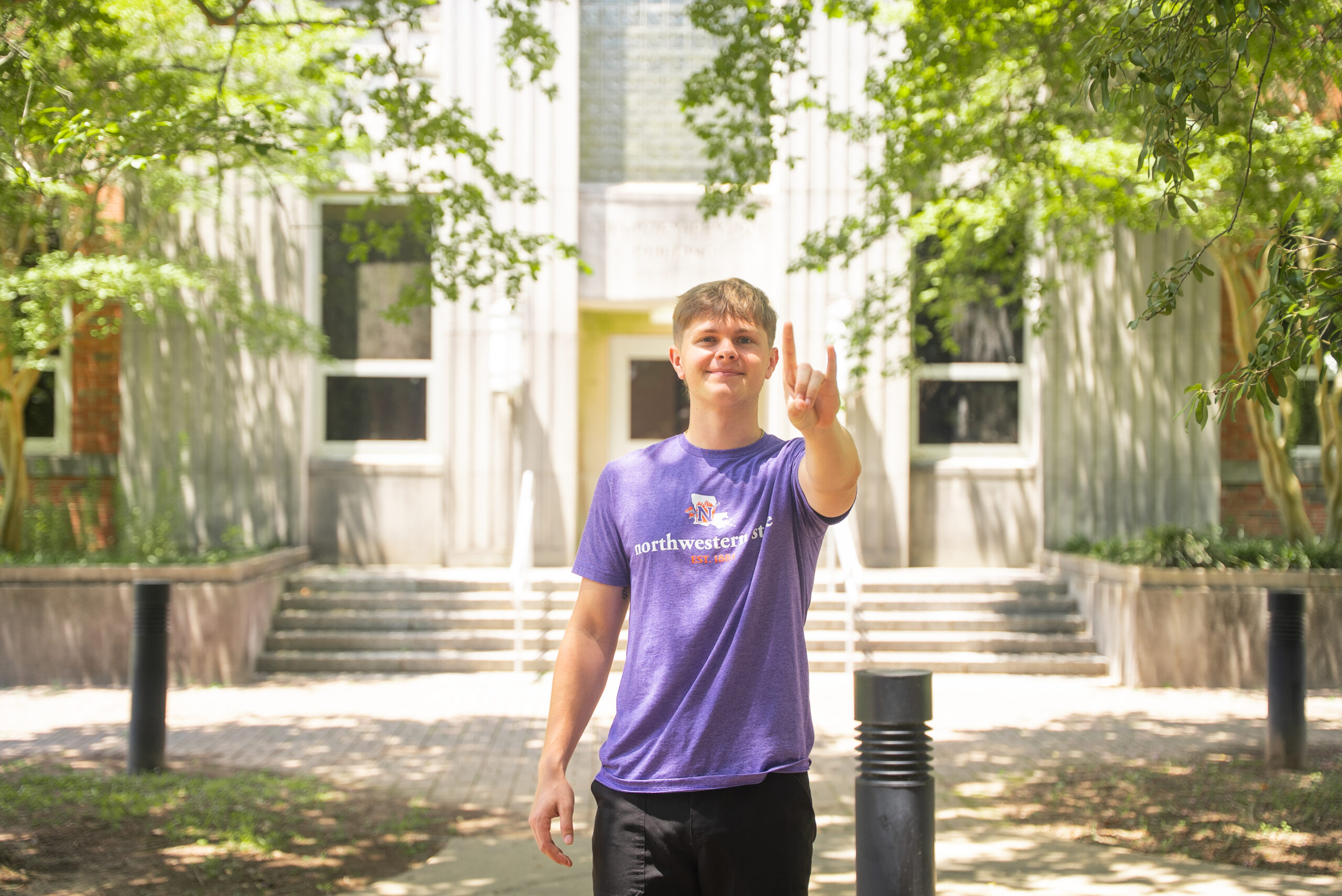 NSU Nursing student poses in front of Nursing academic building