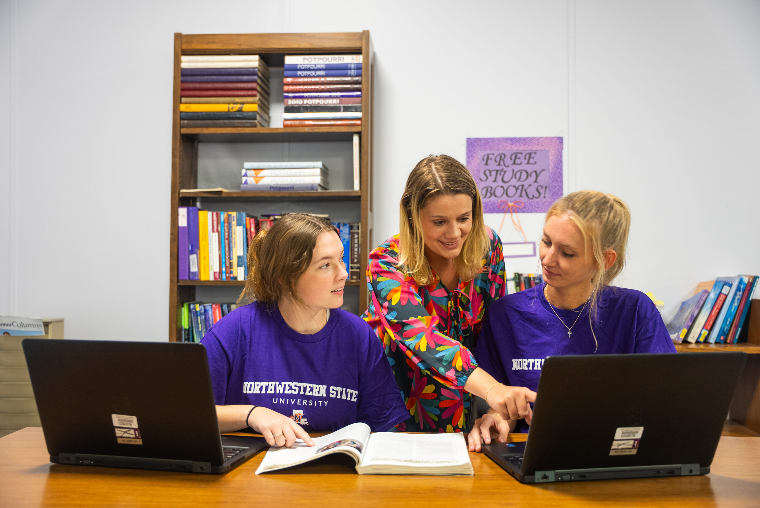 NSU staff member assists students in the library