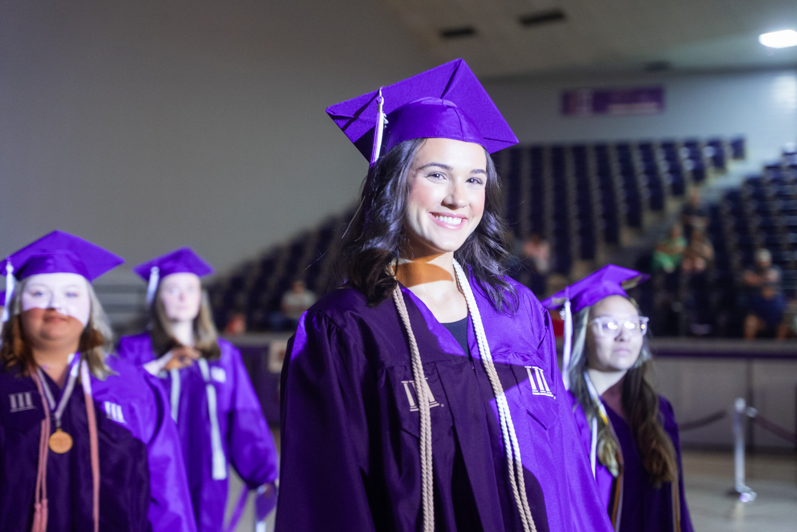 NSU Graduate smiling as they enter the commencement ceremony