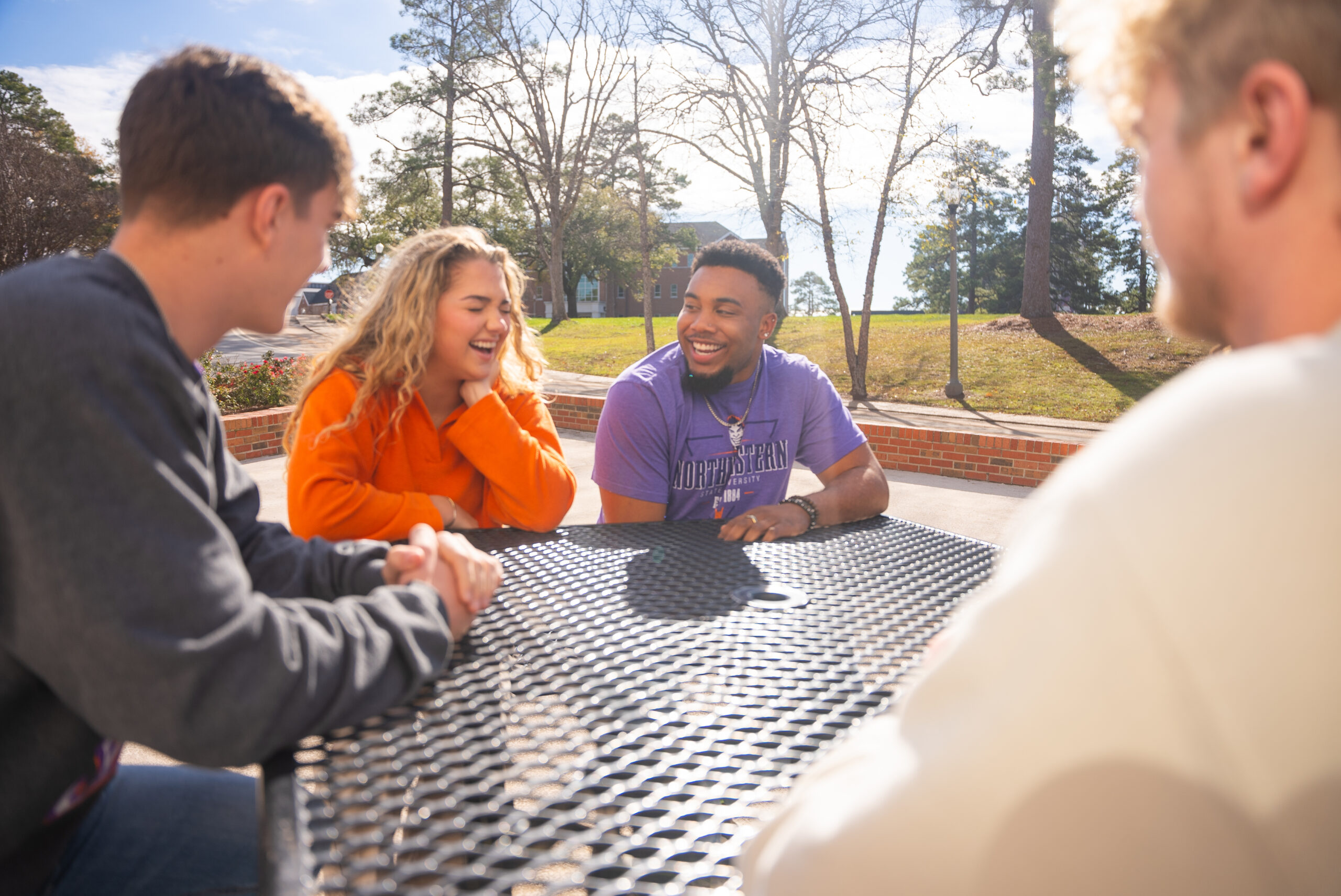 NSU students gather on a picnic table outside of the Student Union