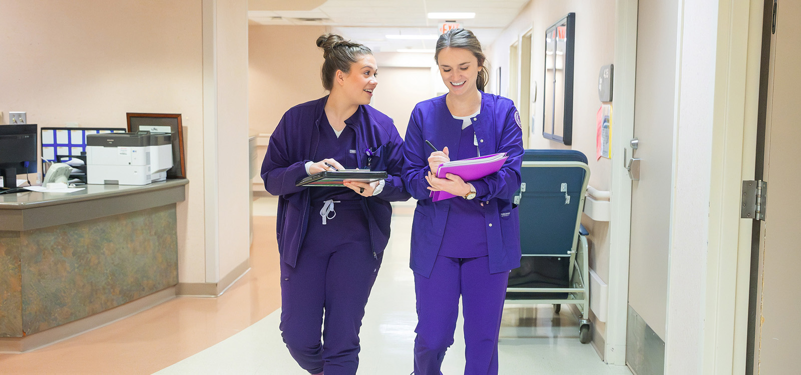 NSU Nursing students walking down hallway at hospital.