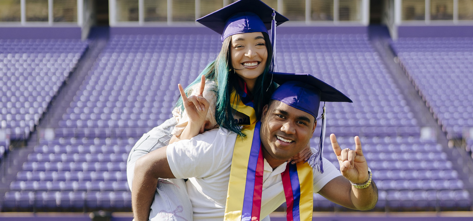 Two international students celebrate graduation at Turpin Stadium in Natchitoches, LA.