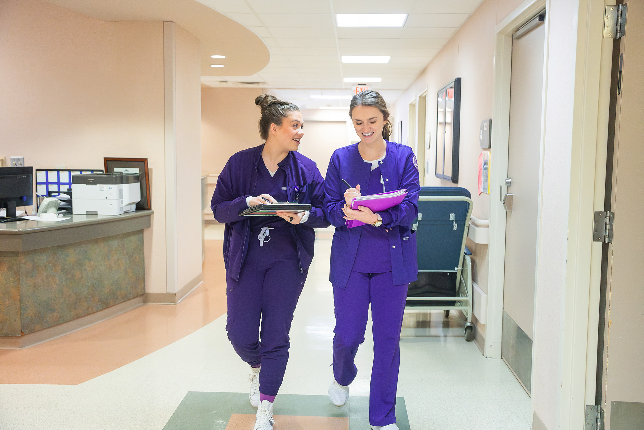 2 NSU Nursing students walking in a hospital hallway