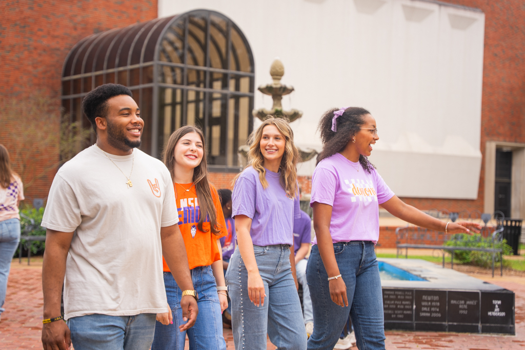 A group of NSU students walk through plaza on campus