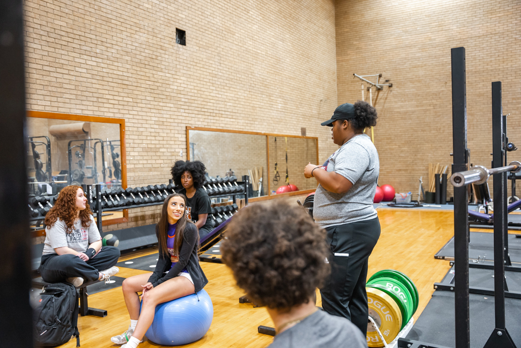 NSU instructor stands before class in the Health & Human Performance Gym