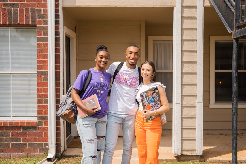 A group of NSU students pose for a photo outside a residential community