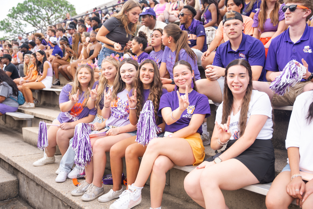A group of NSU students pose for a photo at a football game