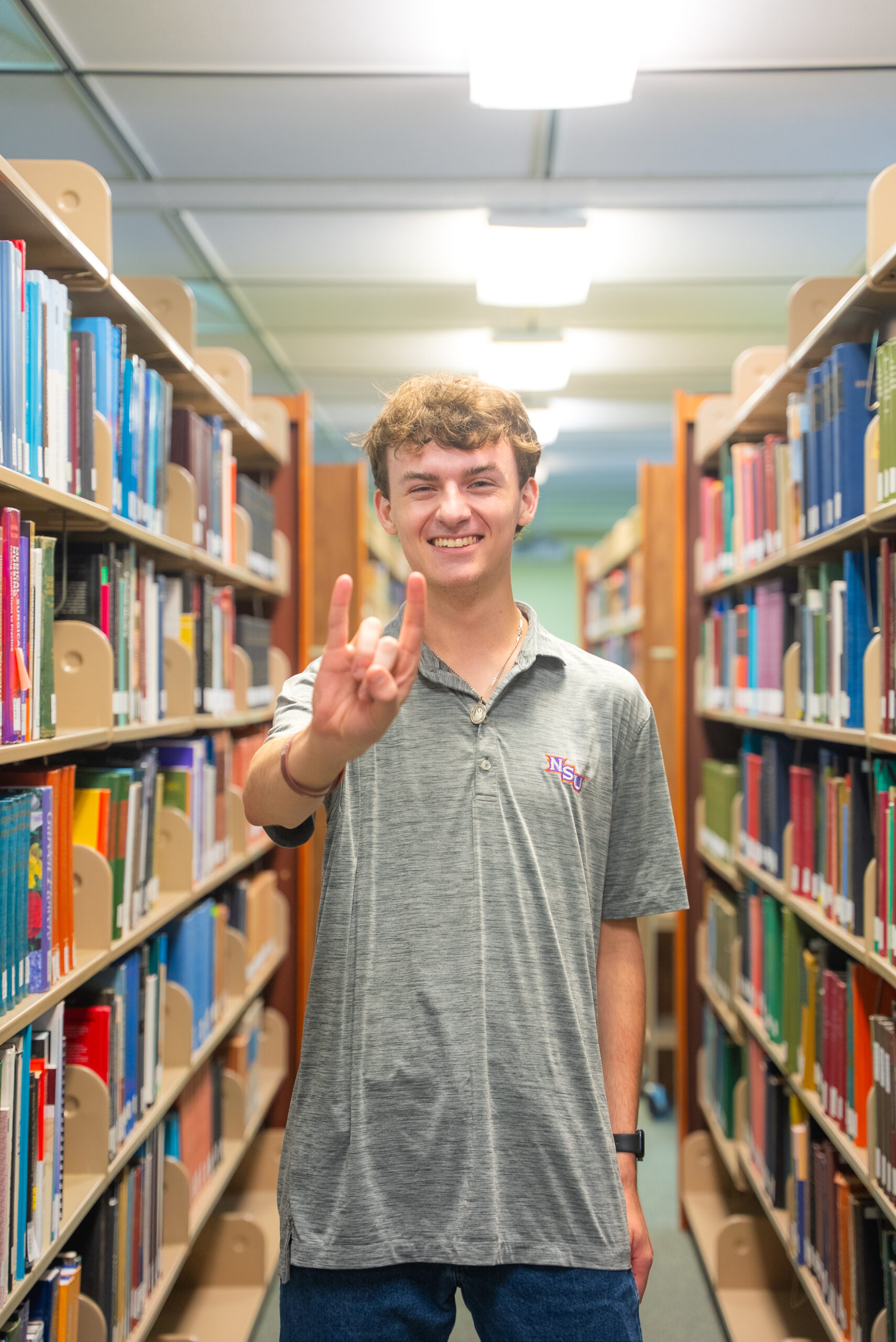 NSU student poses for a photo in the library
