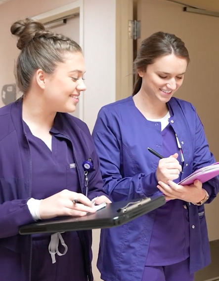 Two NSU students walking down hospital hallway.